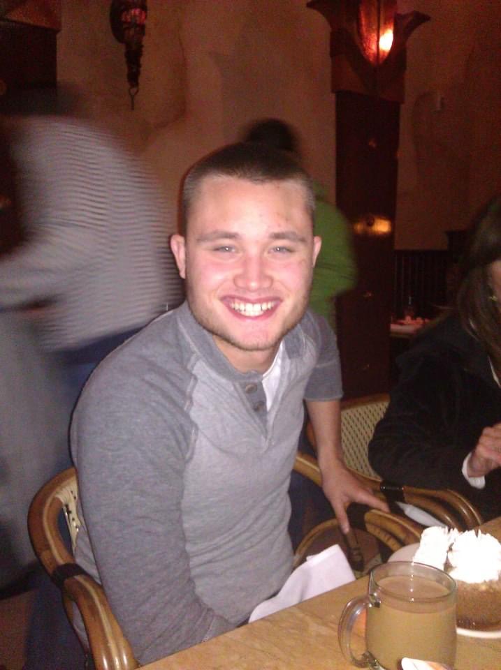 Ryan smiling at a restaurant in a gray shirt